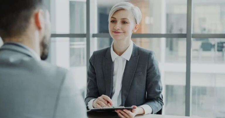 HR and IT colleagues comparing human capital management software on a laptop in an office
